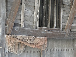 Fishing net hanging in front of wooden window